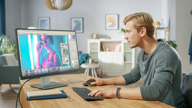 Woman sitted in front of a computer editing photos